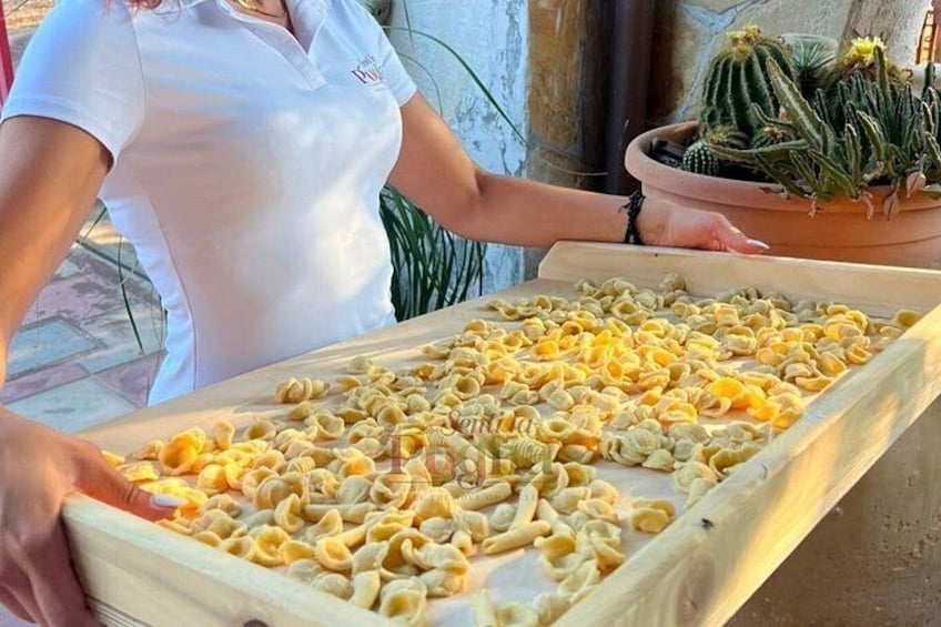 A person holding a tray of pasta. 3