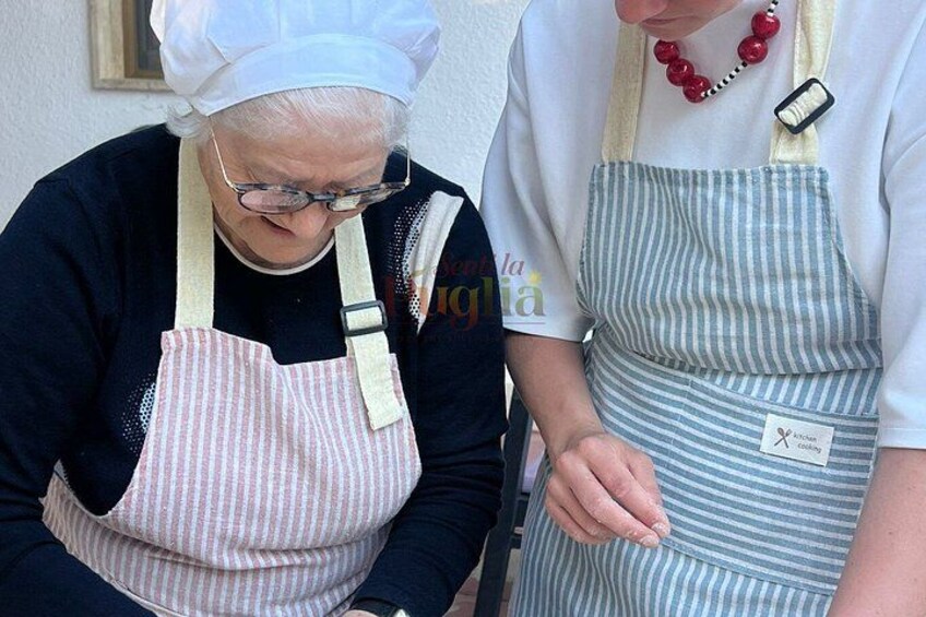 Two individuals wearing aprons, one with a striped apron and the other with a pink apron. 3