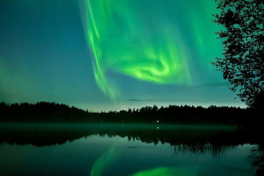 A night sky with the Northern Lights over a calm lake reflecting the lights. 3