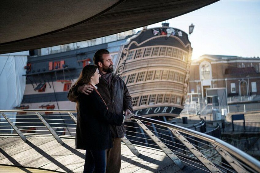 A couple embracing on a bridge with a historic building in the background. 5