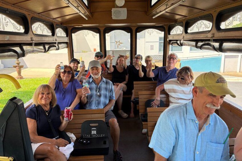 Eine Gruppe von Personen sitzt in einer Trolley-ähnlichen Bahn, auf der vorne 'STAR TROLLEY' sichtbar ist. 2