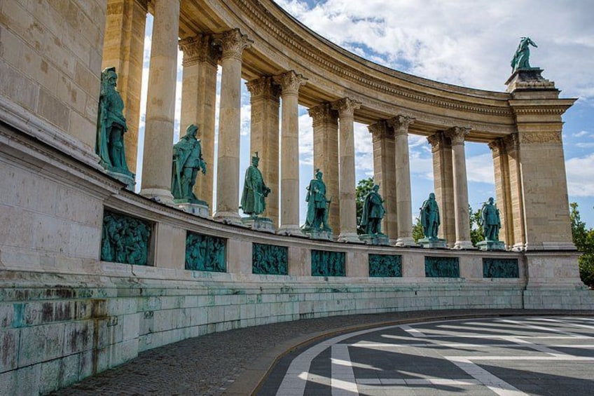 Un imponente edificio neoclassico con una facciata curva, ampie colonne e statue. 2