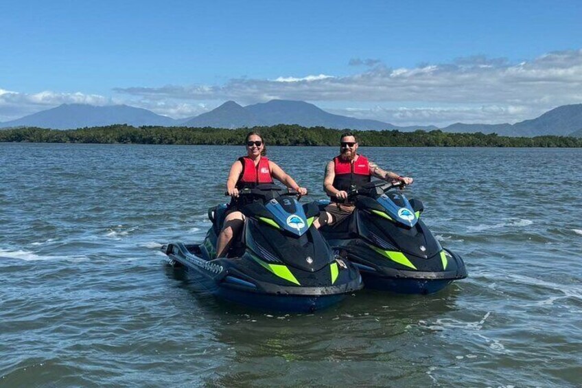 Twee personen waterskiën op een meer, met bergen op de achtergrond. 5