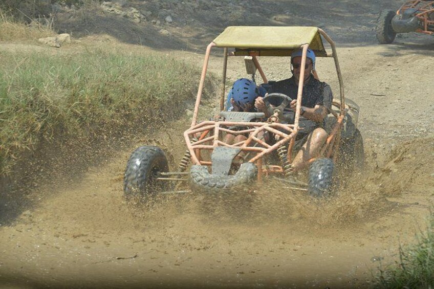 A person driving a dune buggy on a dirt path. 5