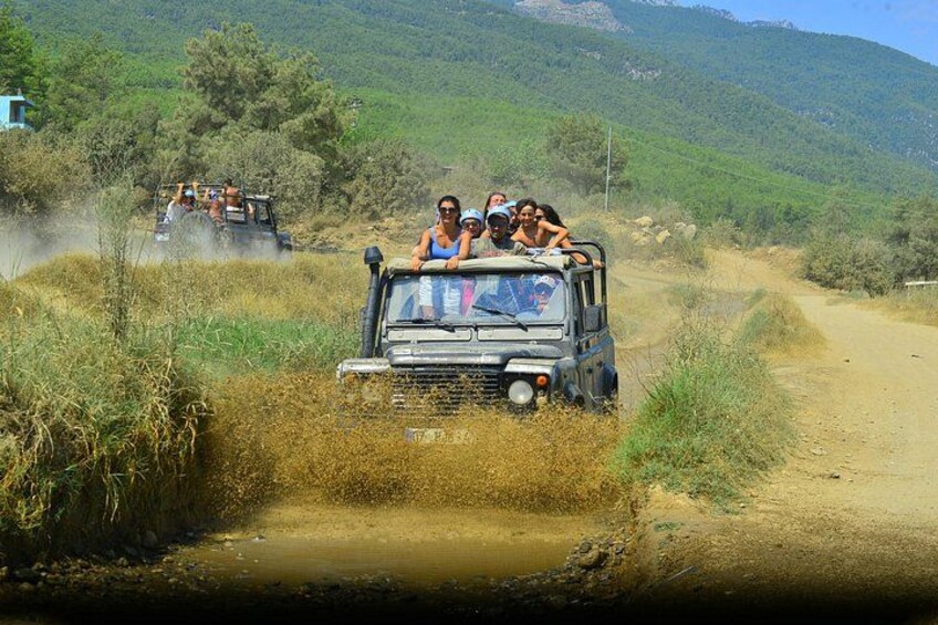 A vehicle navigating a dirt road with passengers. 4