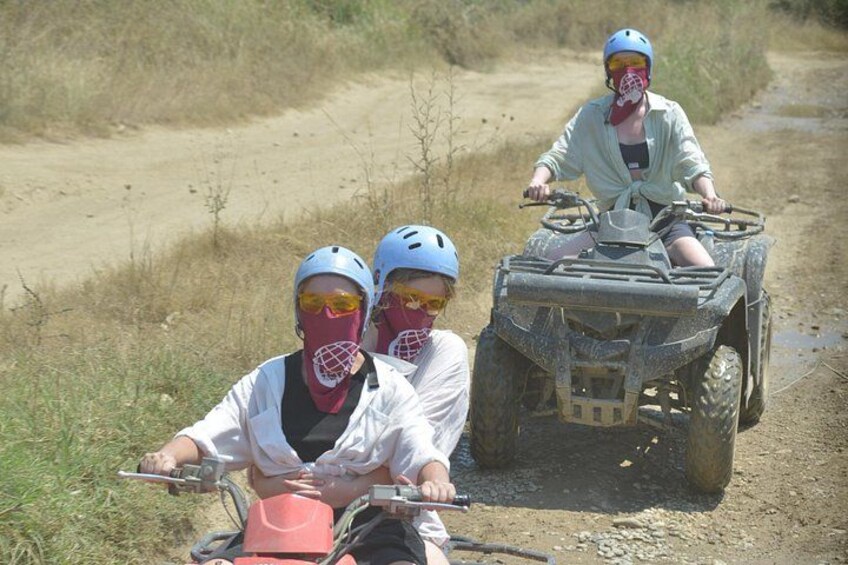 Three people on ATVs on a dirt path. 3
