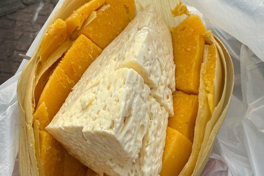 A container with sliced mangoes and a large piece of cheese. 3