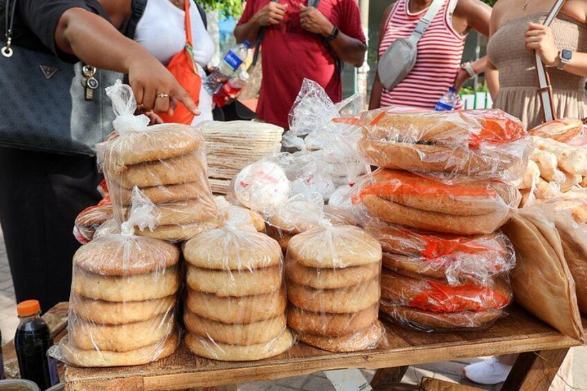 A vendor's table with stacks of bread wrapped in plastic. 2