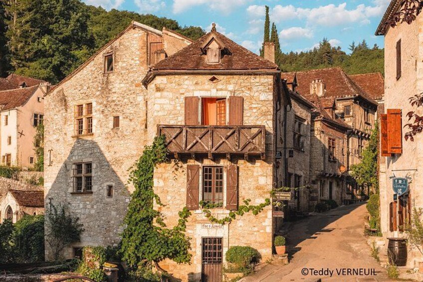 Un bâtiment en pierre doté d’un balcon, entouré d’autres bâtiments traditionnels dans un village. 4