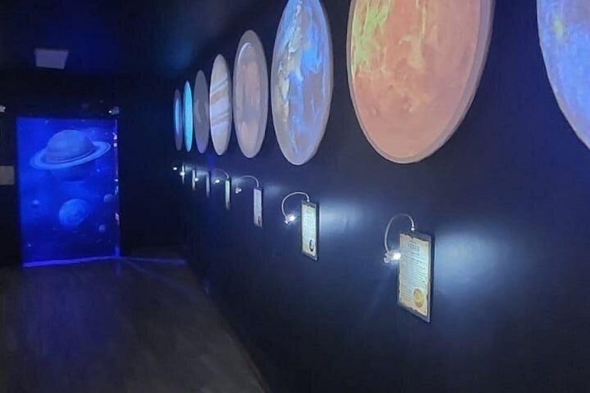 Une exposition de musée présentant des modèles de planètes et des panneaux d’information. 5