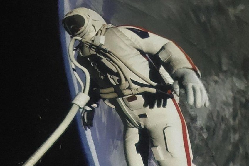 Un astronaute en combinaison spatiale, relié par un câble, flotte dans l’espace, la Terre se détachant en arrière-plan. 2