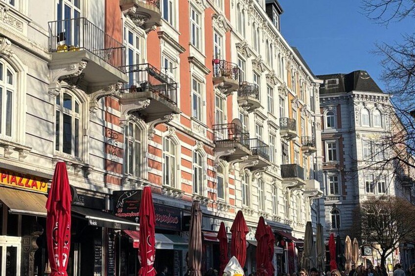 A row of red umbrellas, a building with ornate architecture, and a sign that reads 'Piazza.' 5