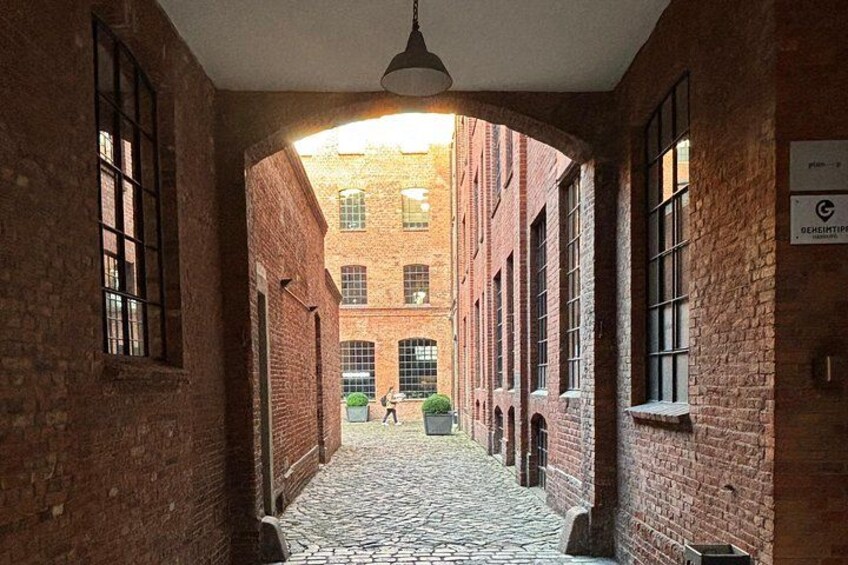 A brick building with a cobblestone courtyard, large windows, and a hanging light fixture. 3