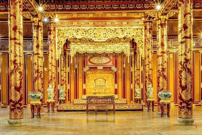 An ornate temple interior with golden decorations, a central altar, and intricate carvings on the pillars. 4
