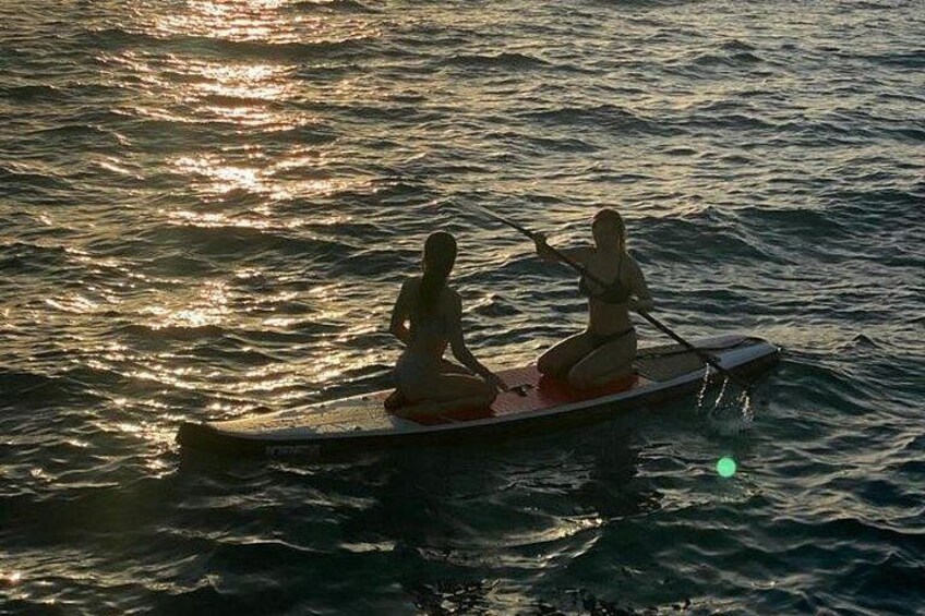Dos personas remando un bote en aguas tranquilas al atardecer. 3