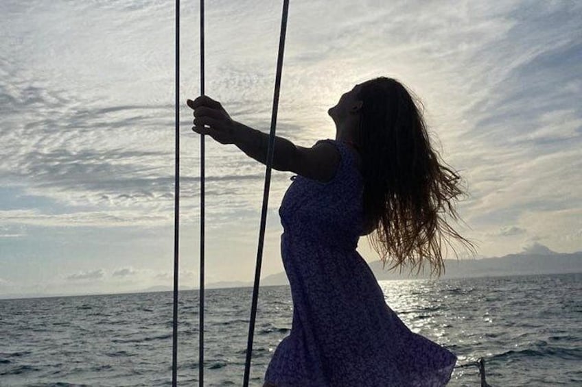 Una persona en un velero con el océano y un cielo nublado al fondo. 2