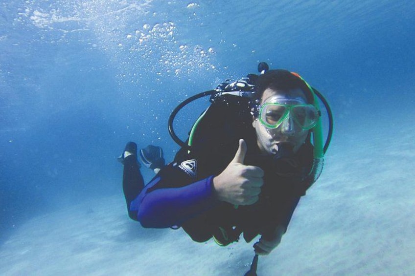 A person underwater giving a thumbs-up. 2