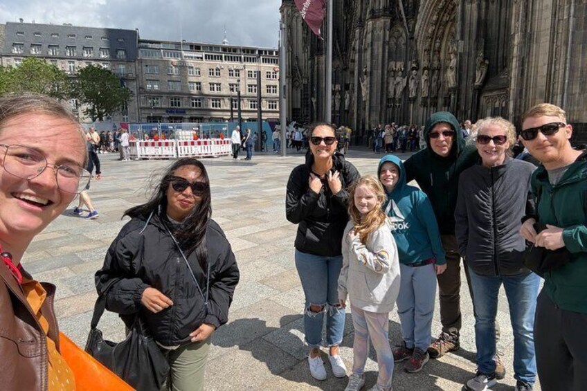Eine Gruppe von Personen steht vor einem großen, historischen Gebäude mit aufwendiger Architektur. 2