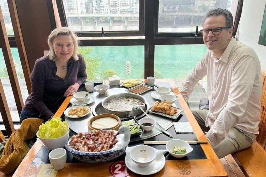 A dining table with various dishes, a bowl of soup, chopsticks, and a cup. 4