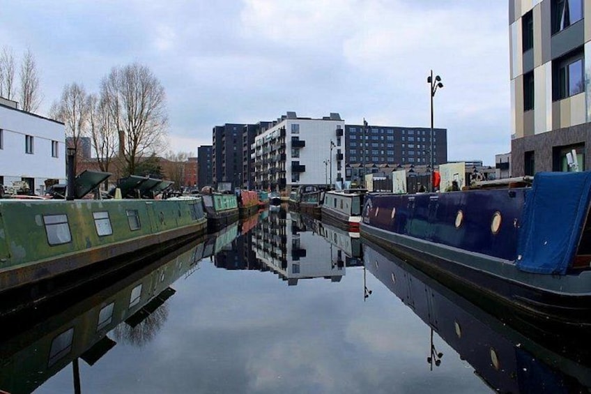En kanal med både, bygninger og en klar himmel. 5