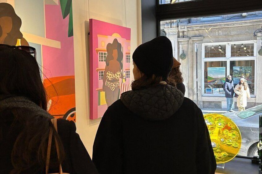 Persone che osservano opere d'arte in una galleria. 4