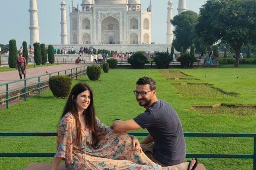 Una coppia seduta su una panchina con il Taj Mahal sullo sfondo. 2