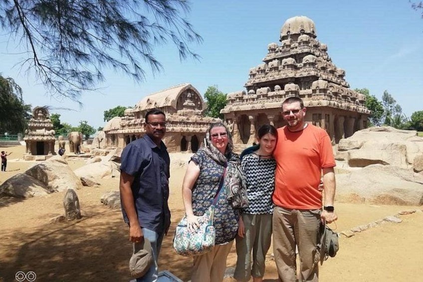 Un groupe de personnes se tient devant d’anciennes constructions en pierre ornées de sculptures complexes. 3