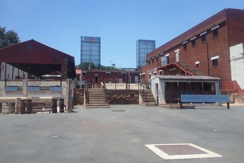 Ett industriområde med byggnader, en överbyggd gångväg och en trappa som leder upp till en högre nivå. 4