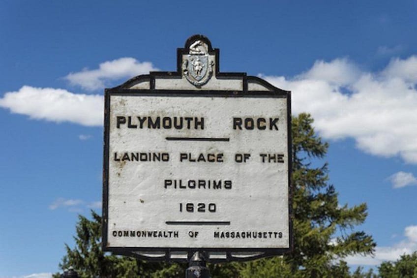 A historical marker sign for Plymouth Rock, indicating it as the landing place of the Pilgrims in 1620, located in Massachusetts. 4