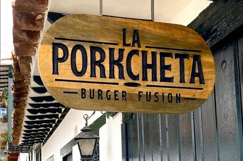 A wooden sign with 'LA PORKCHETA BURGER FUSION' written on it. 4