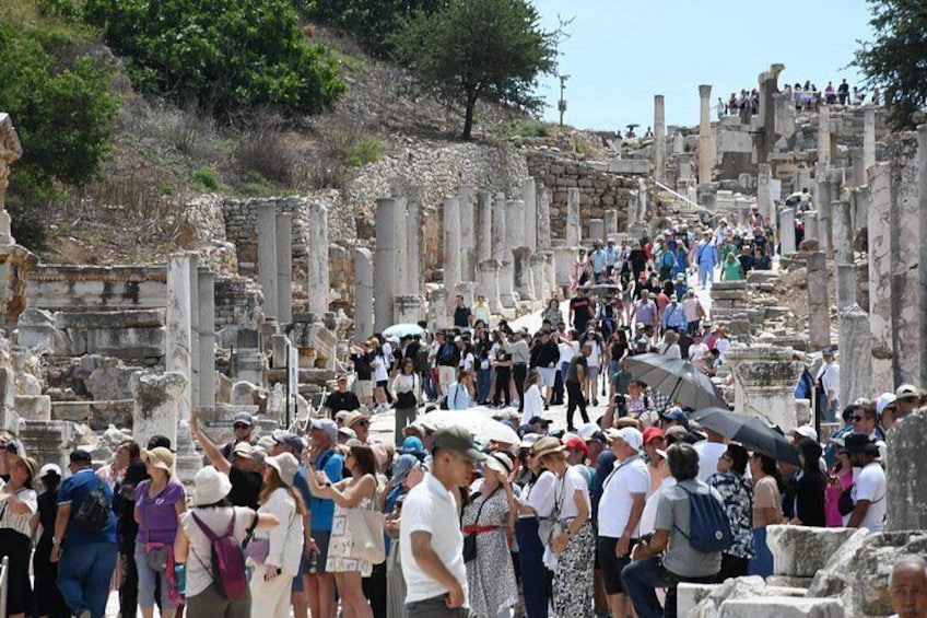 Ancient ruins with columns and steps, surrounded by tourists. 5