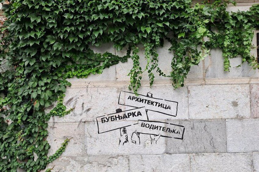 A wall with graffiti and a sign indicating directions to 'Архитектурка' and 'Водителька.' 4