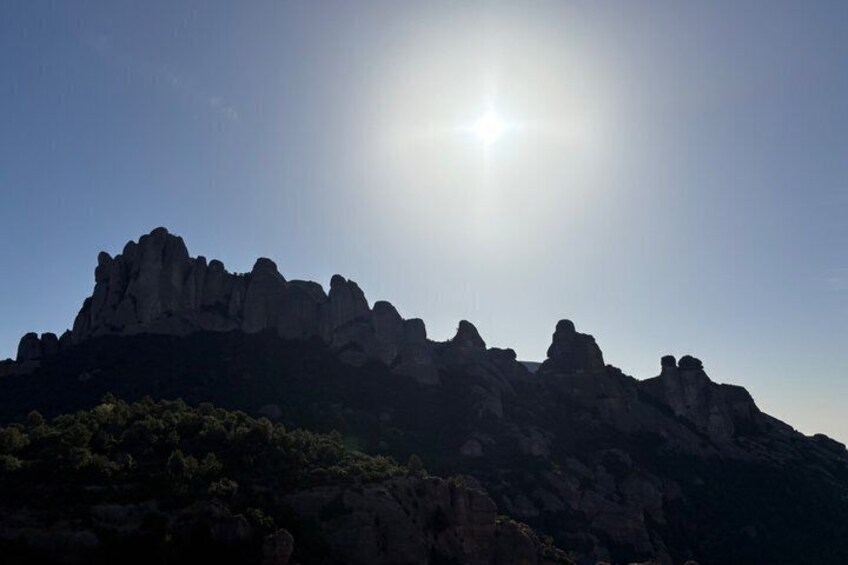 A mountain range with a clear sky and the sun shining. 4