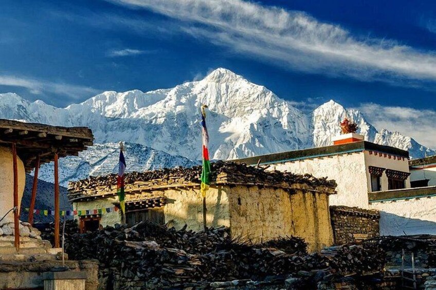 A mountainous landscape with snow-capped peaks, traditional buildings, and flags. 3