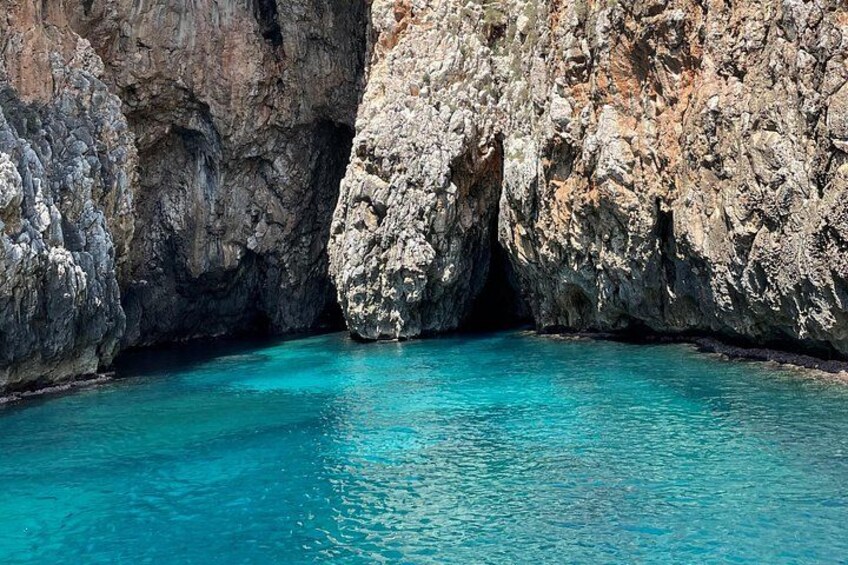 A clear blue sea with rocky cliffs. 4