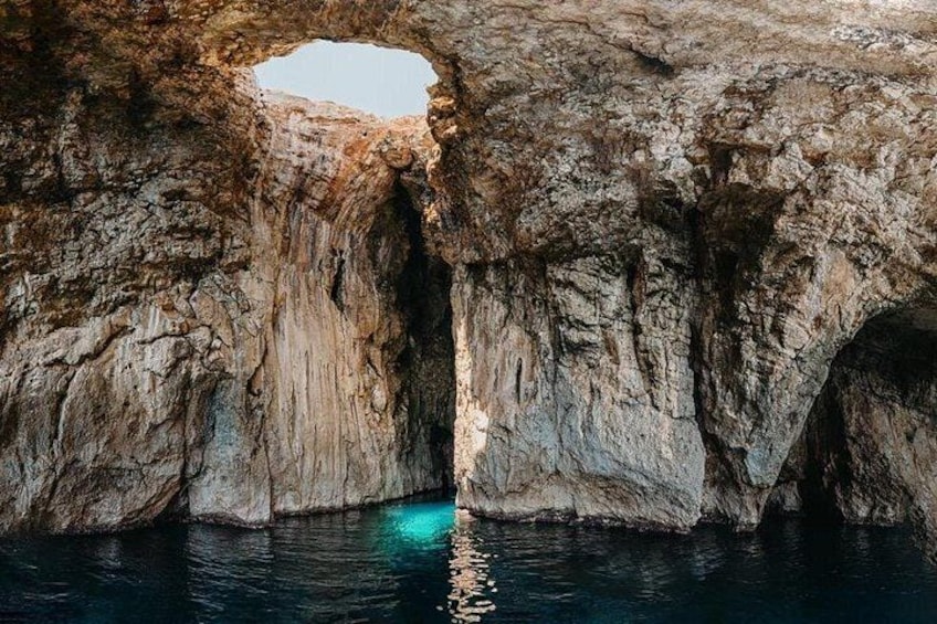 A natural rock formation with a large archway over water. 5