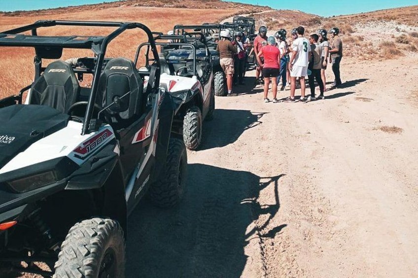 Vehículos todoterreno estacionados en un camino de tierra, con gente cerca. 4