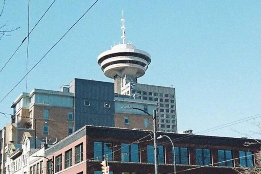 A building with a distinctive tower and a modern structure with a flat roof. 4