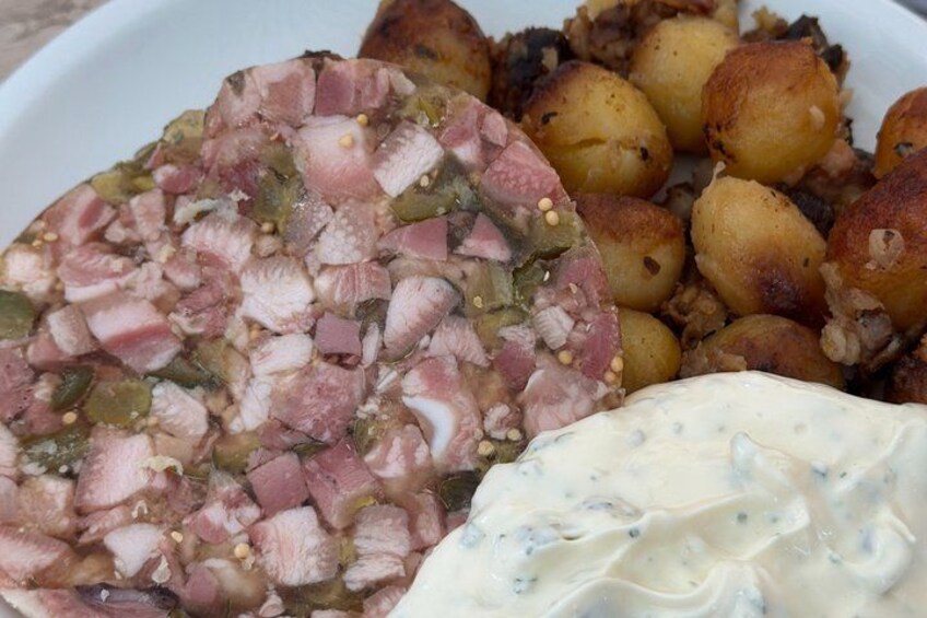 A plate with a meat dish, roasted potatoes, and a creamy sauce. 2