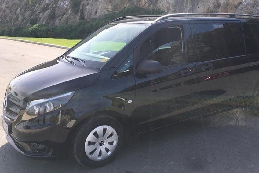Un SUV negro estacionado sobre una superficie pavimentada con un paisaje rocoso al fondo. 4