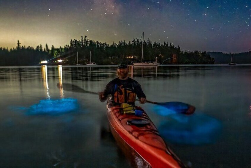 A person kayaking on a calm lake at night with a starry sky. 5