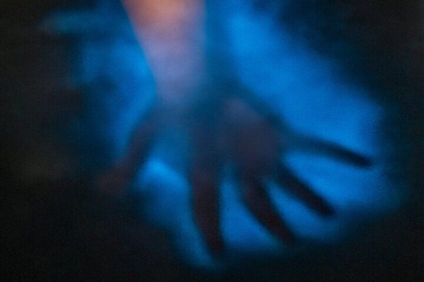 A blurred figure with outstretched arms in a dark setting. 4