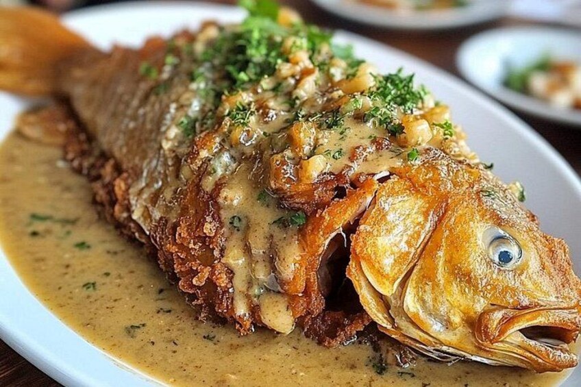 Pescado frito entero con salsa cremosa y adornado con hierbas. 3