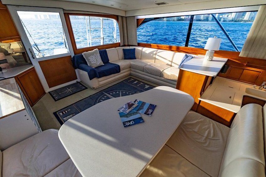 L’intérieur d’un yacht comprenant un coin repas, un canapé et une table avec des magazines. 4
