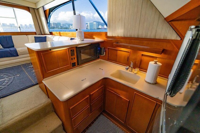 Cocina compacta con muebles de madera, un microondas y un lavabo. 3