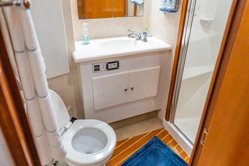 Un baño pequeño con inodoro, lavamanos y ducha. 2