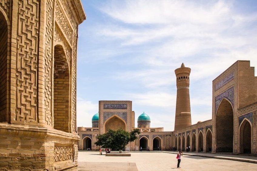 Une cour avec un minaret et une mosquée aux coupoles bleues. 2