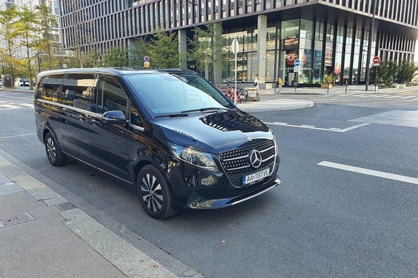 A black Mercedes-Benz van parked on a city street. 5