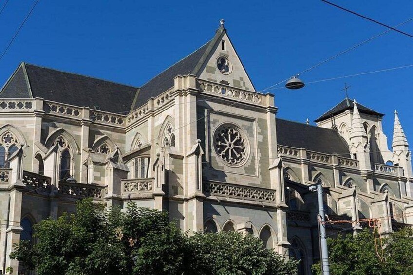 A historic building with intricate architecture, including pointed arches and a large circular window. 1