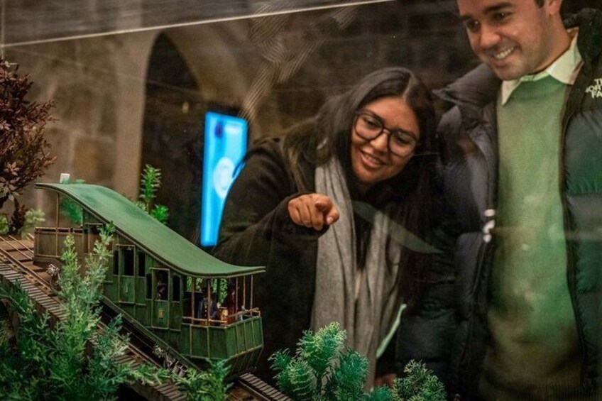 A model train set with a green building and tracks. 2